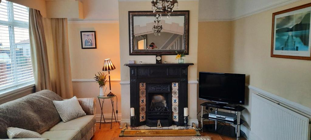 uma sala de estar com um sofá e uma televisão em Cosy and stylish house on the coast near Liverpool em Wirral