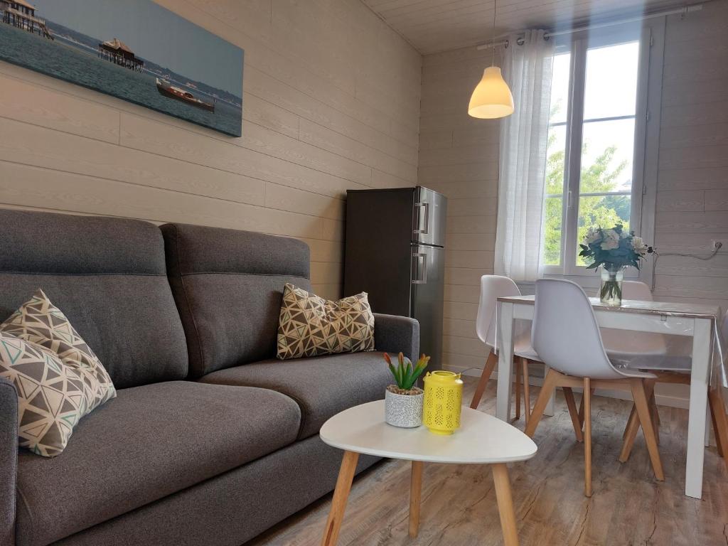 un salon avec un canapé et une table dans l'établissement APPARTEMENT 4 PERSONNES ARCACHON Wifi Parking, à Arcachon