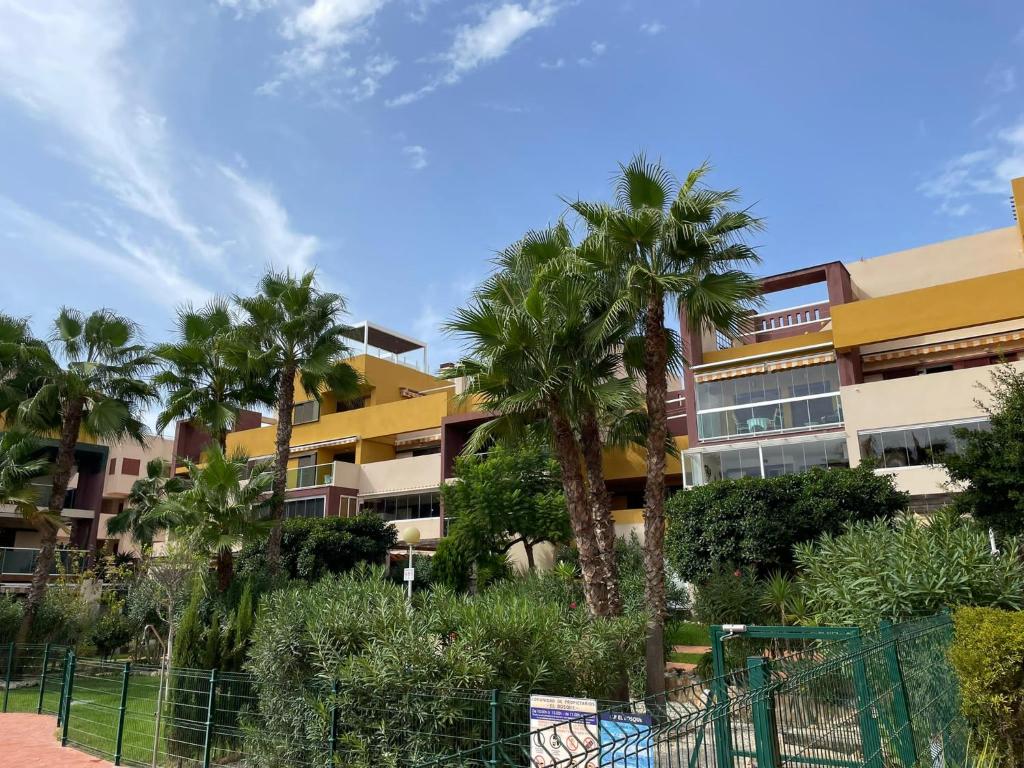 un edificio con palmeras delante en Casa Palmera - El Bosque - Playa Flamenca en Playa Flamenca