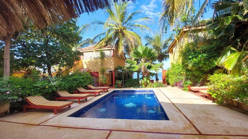 a swimming pool in a yard with chairs and trees at Maison Couleur Passion in Nianing