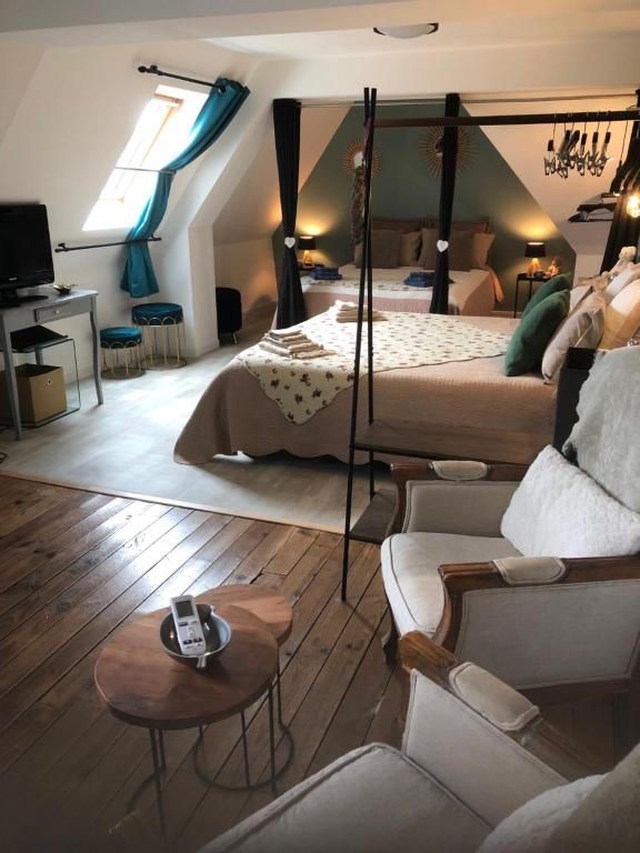 a living room with a bed and a couch at Chambre studio familiale la Brandonnière in Courson