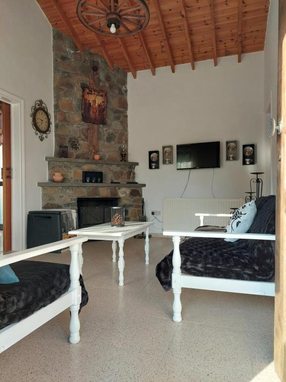 uma sala de estar com 2 camas e uma lareira em Veranda em Agros