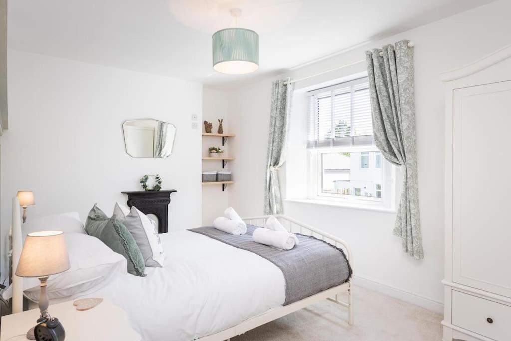 um quarto branco com uma cama e uma janela em *Brand New* Lemon Tree Cottage em Torquay