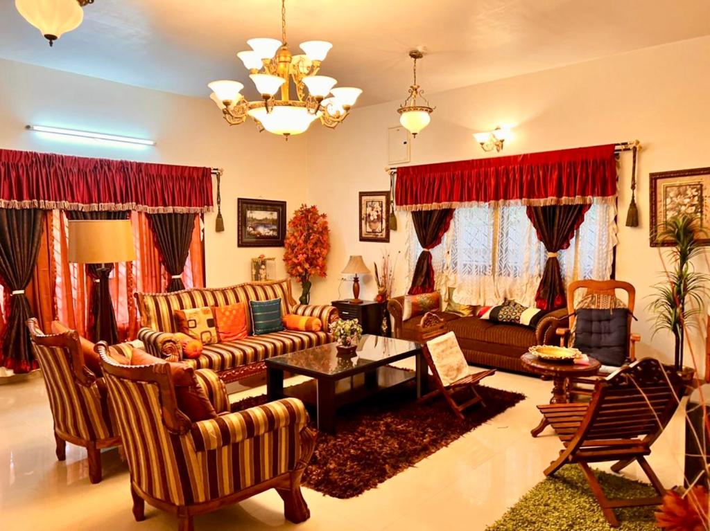 sala de estar con sofás y mesa en Lakshmi Illam Guesthouse for Families only en Kodaikānāl