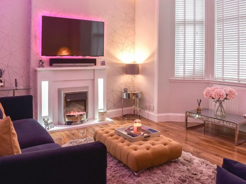 a living room with a fireplace and a tv at Baileyfield Cottage in Edinburgh