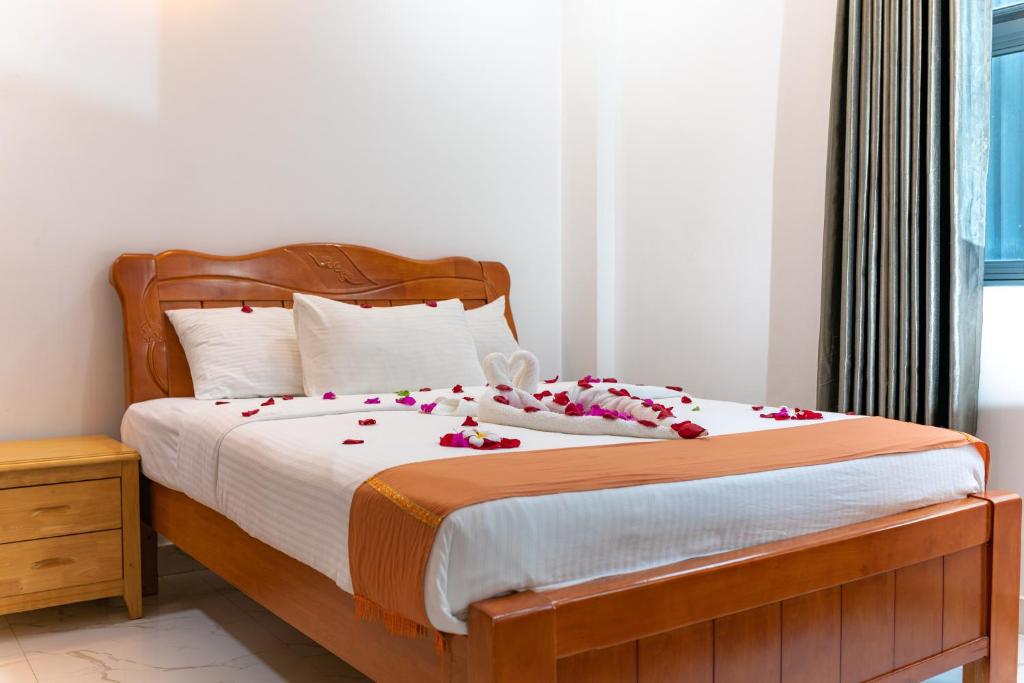 een slaapkamer met een bed met bloemen erop bij White Beach Holiday in Hulhumale