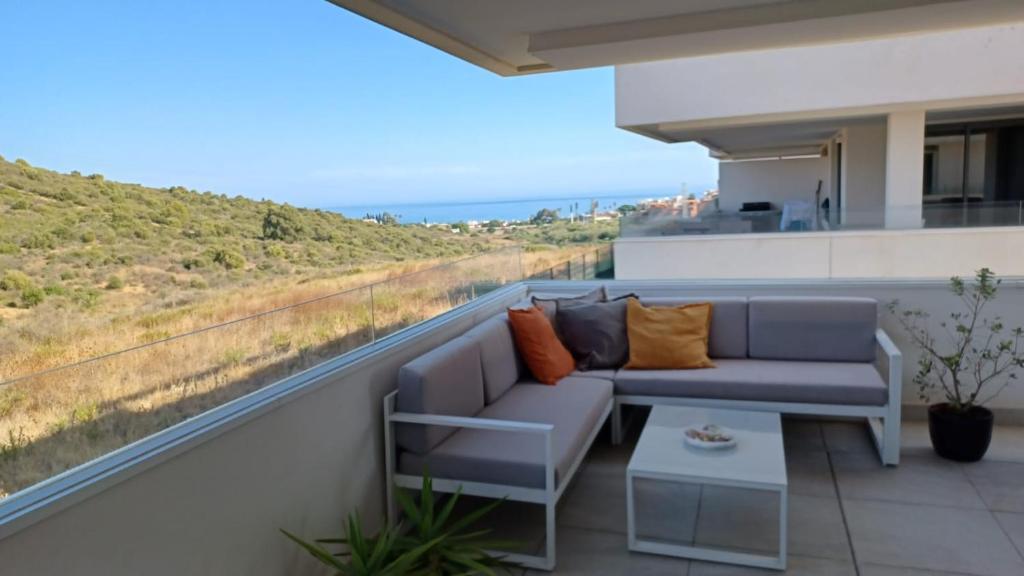 uma varanda com um sofá e vista para o oceano em Serenity Views 3 bedroom seaview em Estepona