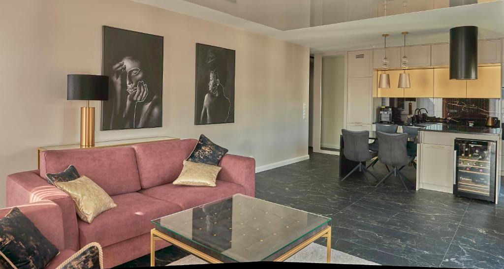 Apartament Primavera 3 MINI SPA Komfort dla grup biznesowych , rodzin ,osób indywidualnych في كيلسي: غرفة معيشة مع أريكة حمراء ومطبخ