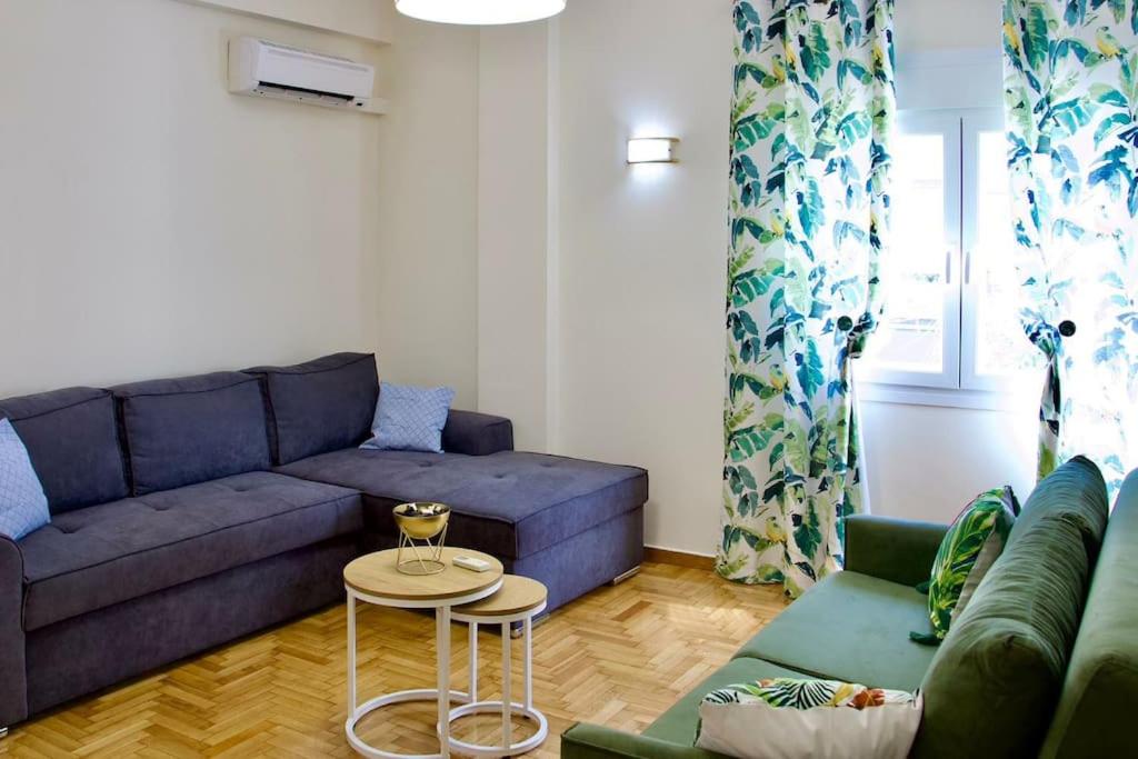 - un salon avec un canapé bleu et une table dans l'établissement Glyfada Path of Poets, à Athènes