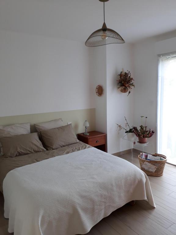 biała sypialnia z łóżkiem i oknem w obiekcie Les coquetières w mieście Roz-sur-Couesnon