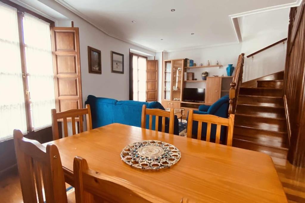 un comedor con una mesa de madera con un plato. en apartamentos lleguera 1, en Llanes