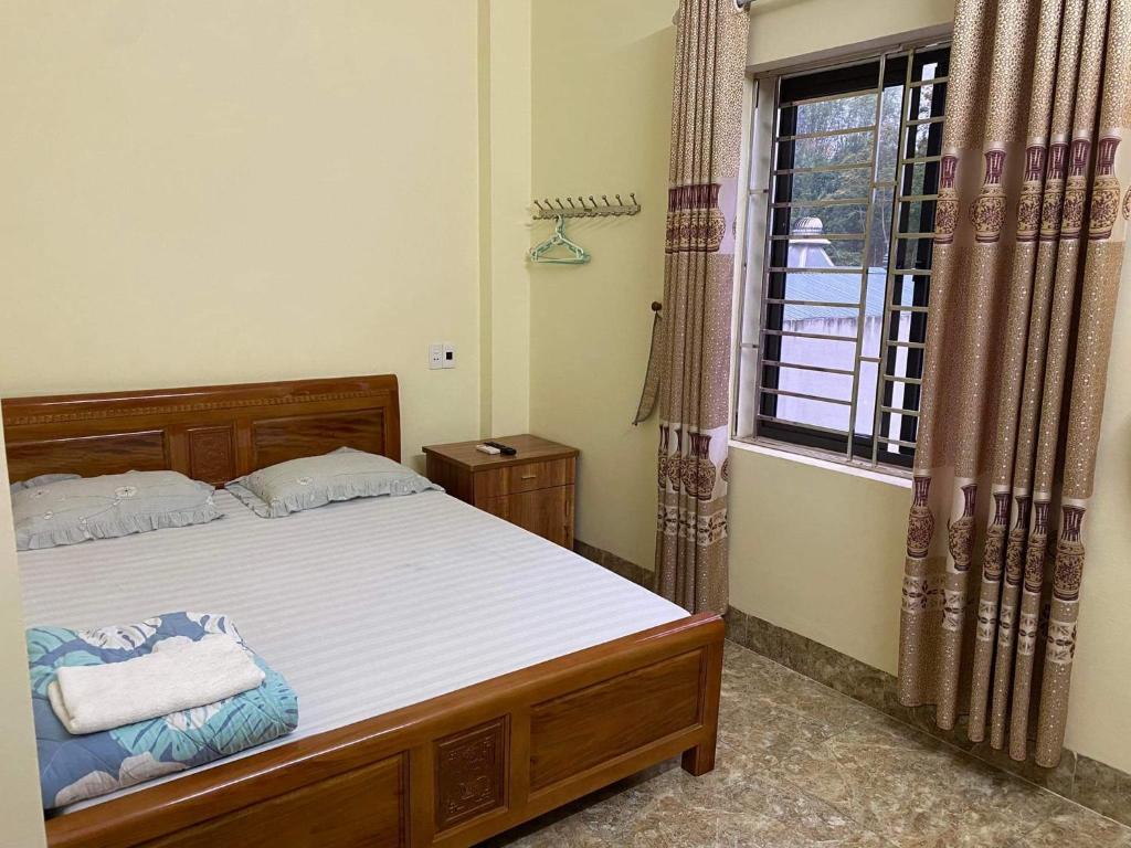 a bedroom with a bed and a window at Nhà nghỉ Tâm Cường in Diện Biên Phủ