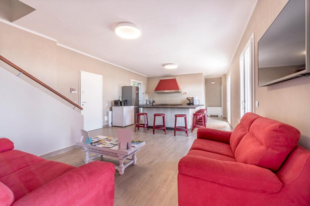 salon z 2 czerwonymi kanapami i stołem w obiekcie Agriturismo Cascina Trevo w mieście Spotorno