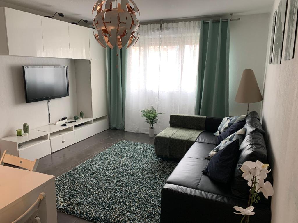 a living room with a couch and a flat screen tv at Superbe appartement neuf T3 de 71m2 en résidence a Marseille in Marseille
