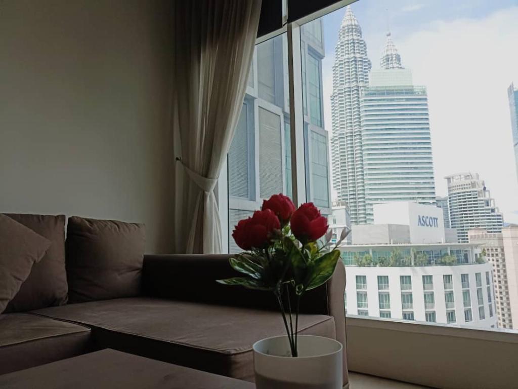 a living room with a couch and a window with red roses at Soho Suites KLCC Kuala Lumpur in Kuala Lumpur