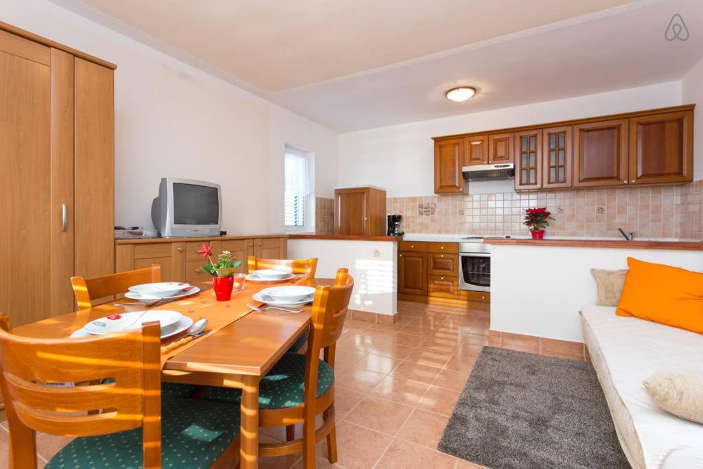 - une cuisine et une salle à manger avec une table et des chaises dans l'établissement Apartmani Lucia, à Rab