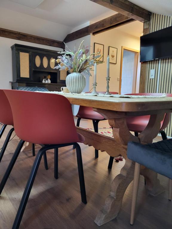 uma sala de jantar com uma mesa de madeira e cadeiras em Countryside apartment em Volkenschwand