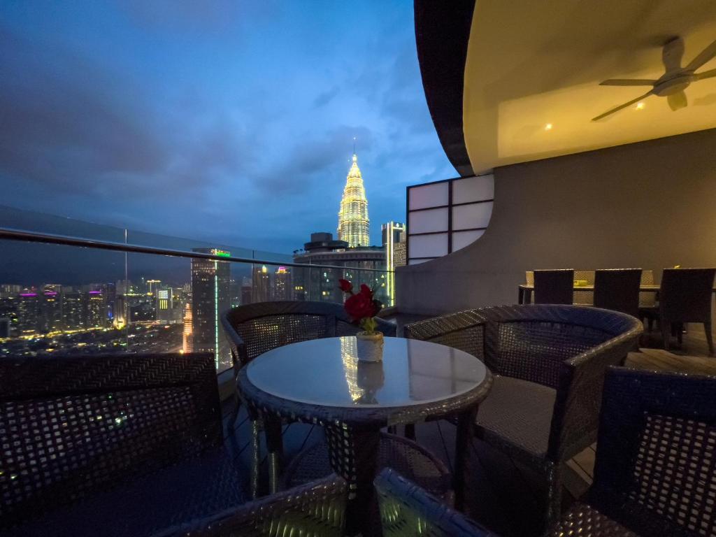 a table on a balcony with a view of the city at Vortex Suites KLCC by Nadia Guesthouse Kuala Lumpur in Kuala Lumpur