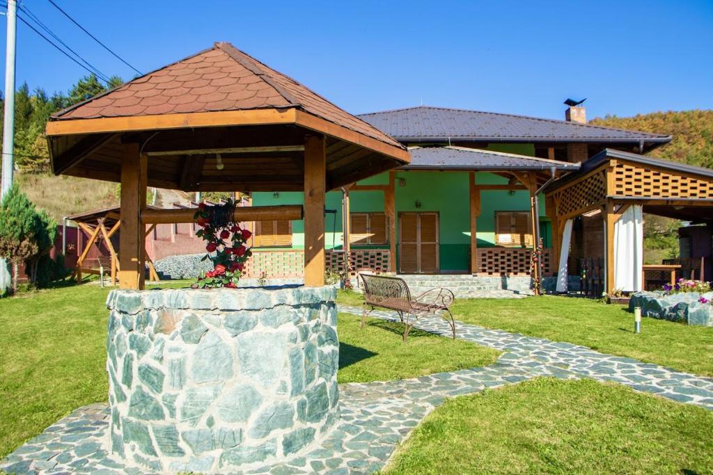 una casa con un cenador y un banco en un patio en Holiday Home Green, en Rakovica