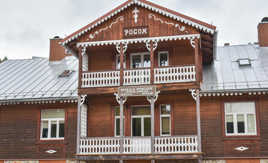 une maison en bois avec un balcon à l'avant dans l'établissement Willa POGOŃ ZD12, à Krynica-Zdrój