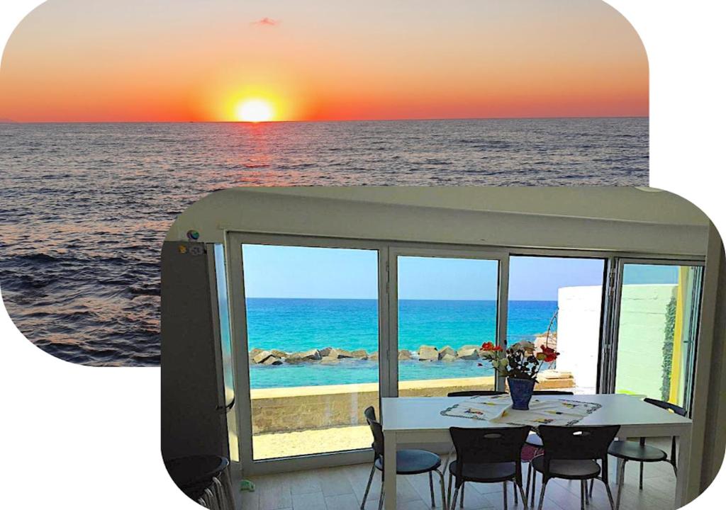 - une table avec des chaises et une vue sur l'océan dans l'établissement Appartamento Pettinato, à Pizzo
