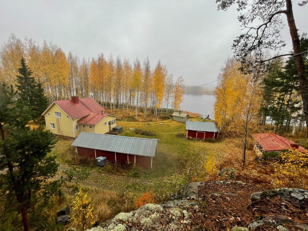 a group of houses on a hill next to a lake at Ulkoporeamme Niemelä in Melkoniemi