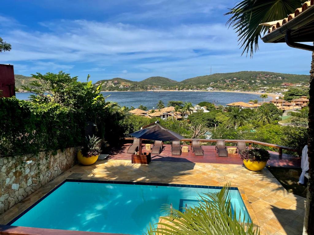 a swimming pool with a view of the water at FERRADURA EXCLUSIVE SEaVIEW in Búzios
