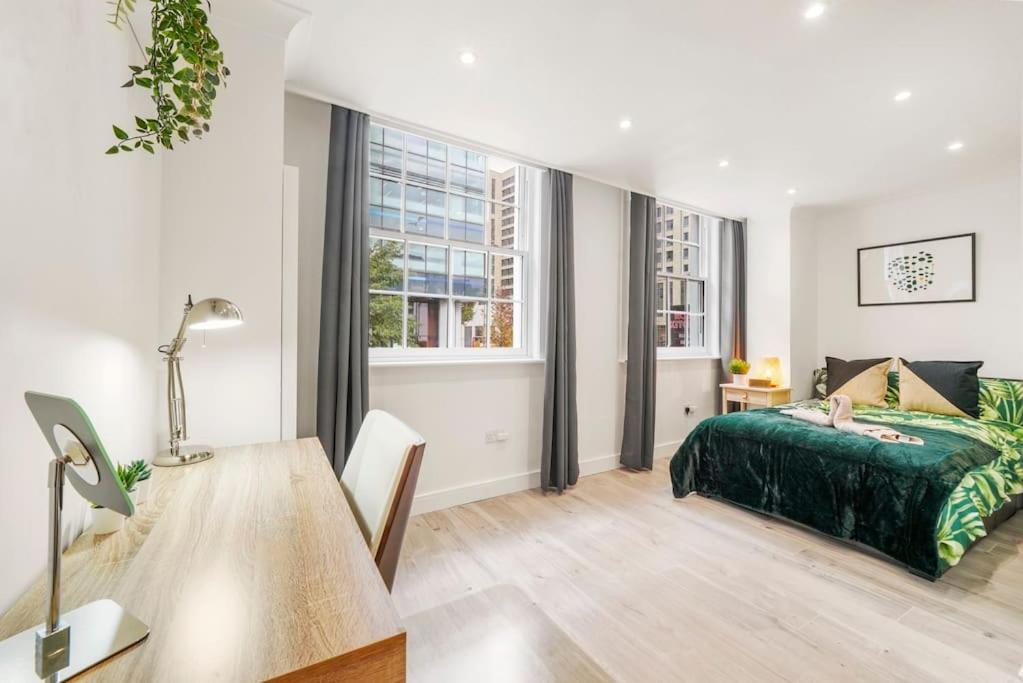 a bedroom with a bed and a desk and a table at Modern 2 bedroom apartment in the heart of London in London