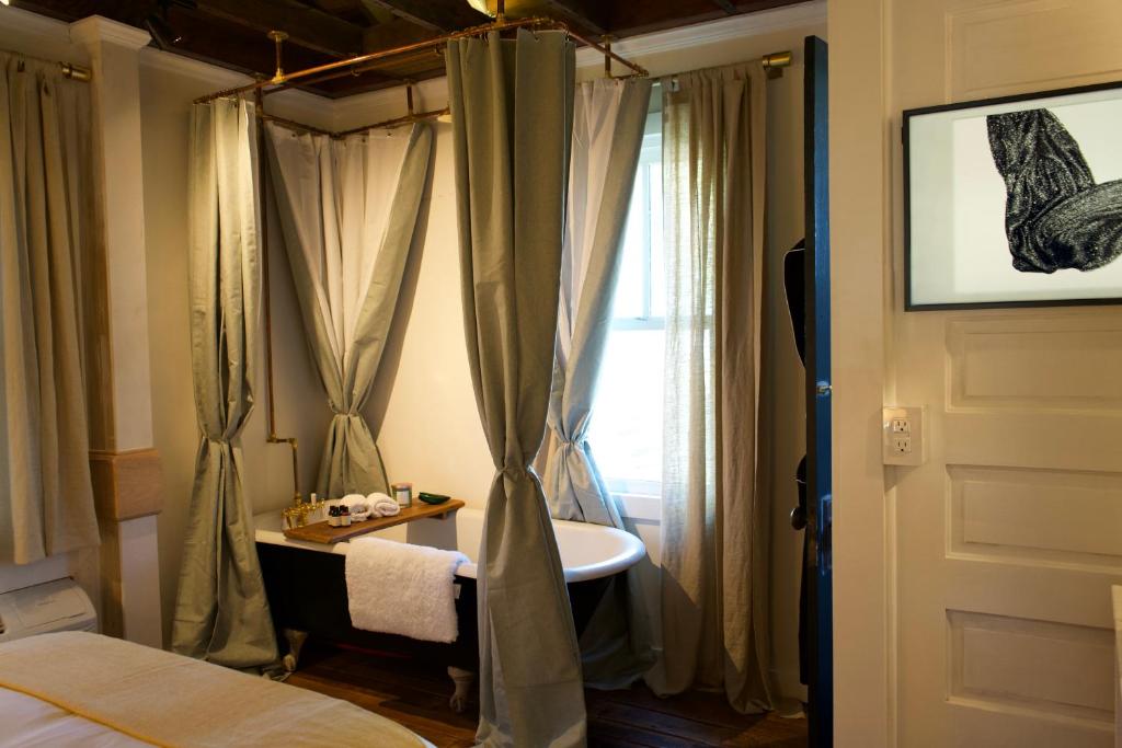 a bedroom with a bed and a sink and a window at Archaic Outhouse in Santee