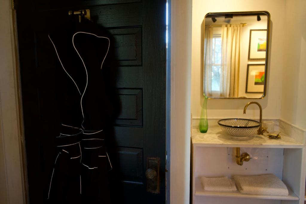 a bathroom with a black door and a mirror at Archaic Outhouse in Santee