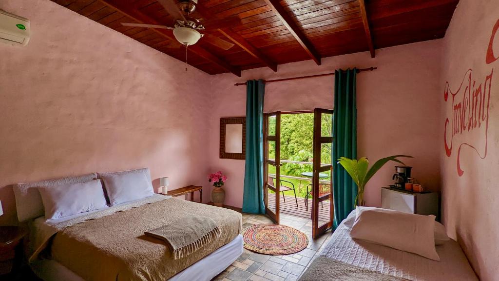 a bedroom with a bed and a sliding glass door at Nova Beautiful boutique hotel Manuel Antonio in Manuel Antonio