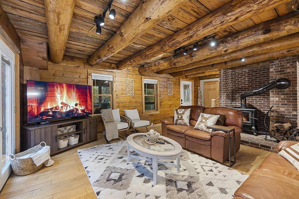 uma sala de estar com um sofá e uma televisão em NEW!! Entire Log Home with *PRIVATE Hot Tub em Thornton