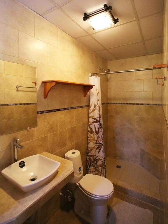 e bagno con lavandino, servizi igienici e doccia. di Gaia Lodge a Boquete