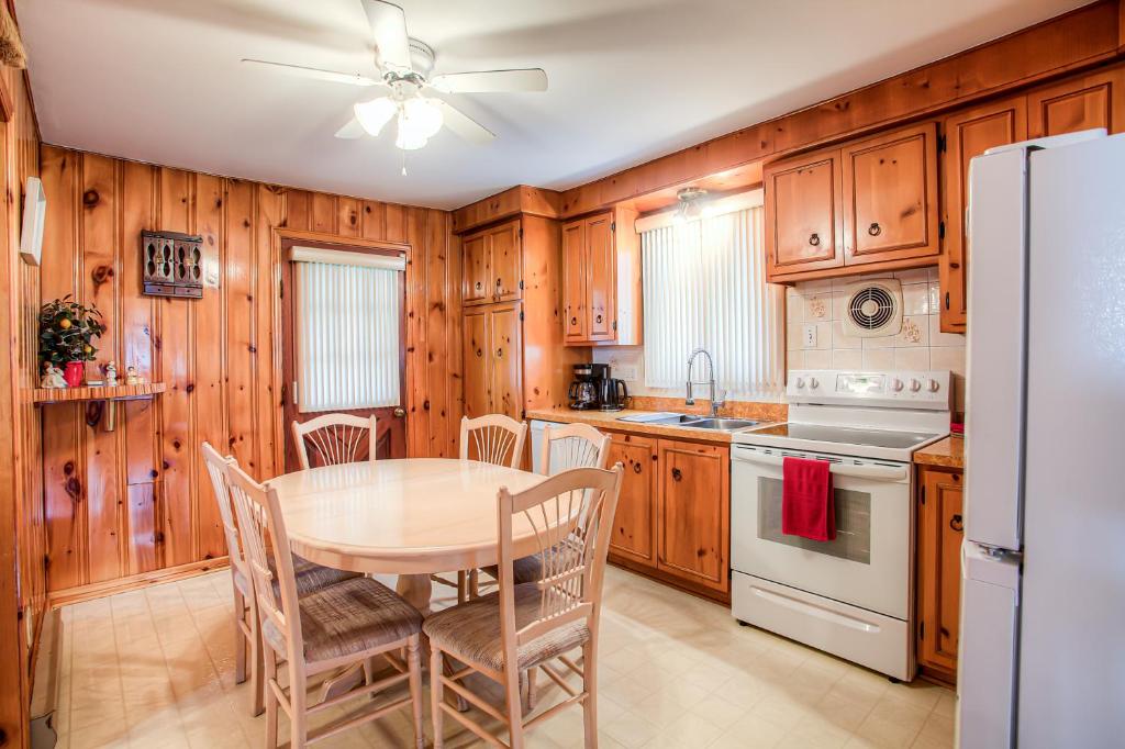 a kitchen with wooden cabinets and a table and chairs at Maison chaleureuse a 15 minutes DT Montréal in Montreal