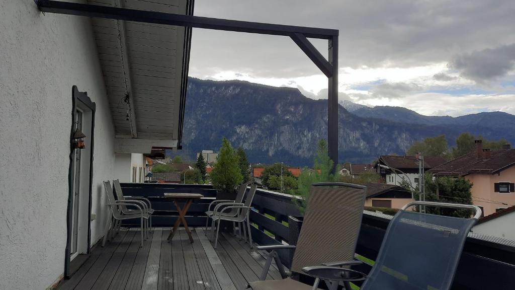 a balcony with chairs and a table and a view of a mountain at Florentiner Haus in Kiefersfelden