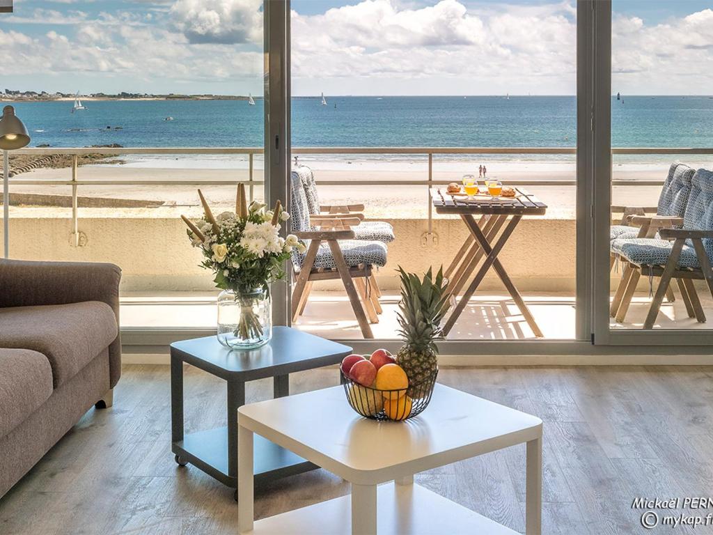 a living room with a view of the beach at Spacieux studio terrasse, mer à 700m commerces, parking privé, Wi-Fi inclu - FR-1-349-116 in Larmor-Plage