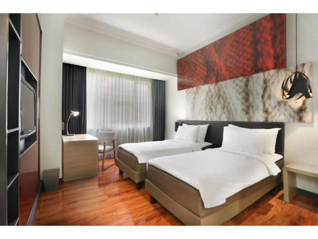 Postel nebo postele na pokoji v ubytování Malyabhara Hotel - formerly Ibis Malioboro