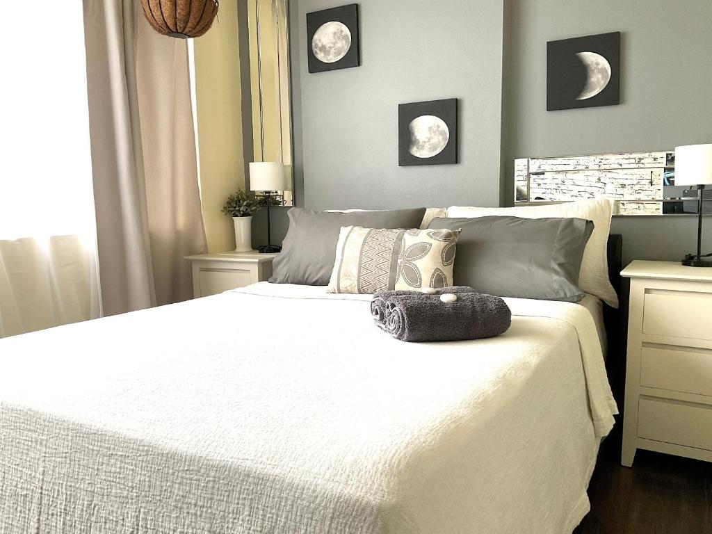 Un dormitorio con una gran cama blanca con almohadas. en Namely Manly, en Sídney