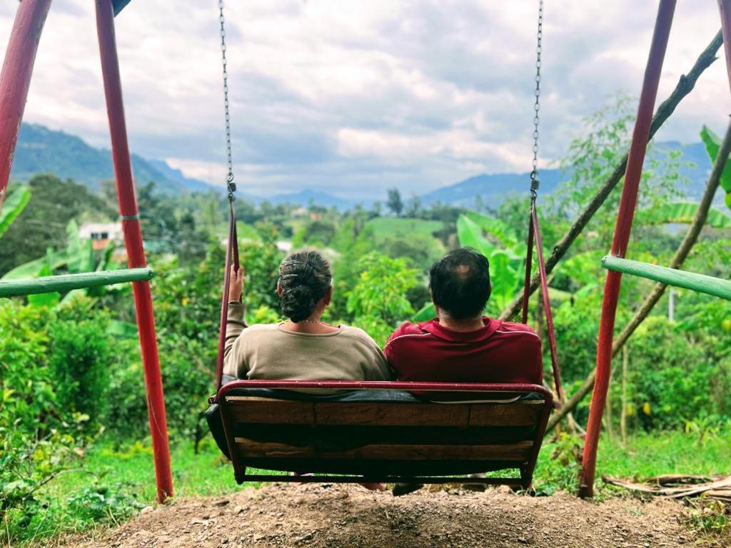 dos personas sentadas en un columpio mirando a las montañas en Posada Lu.Lu, en Choachí