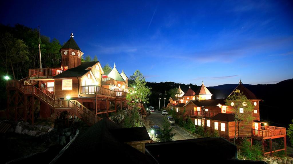 平昌的住宿－Korea Quality Elf Hotel，一座在晚上设有钟楼的大型建筑