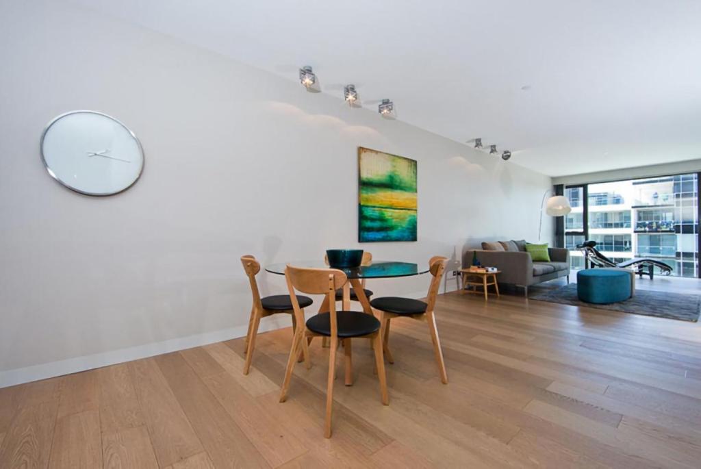 a dining room and living room with a table and chairs at Aurora 14 in Canberra