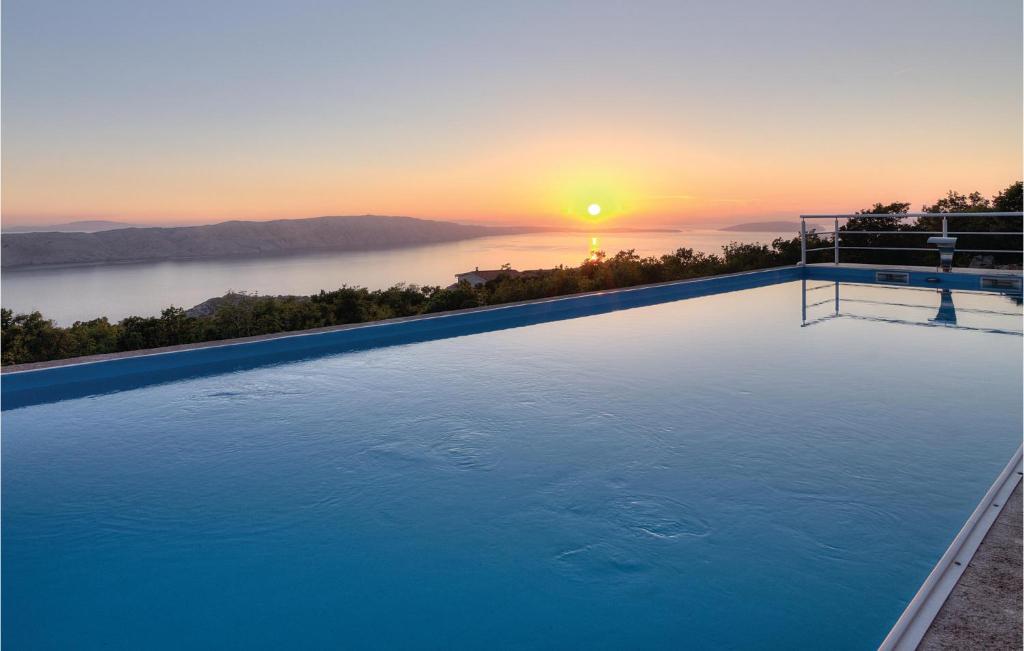 una piscina infinita con una puesta de sol en el fondo en Gorgeous Apartment In Stinica With House Sea View, en Stinica