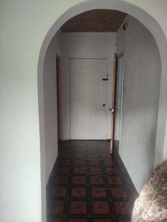 an empty hallway with a white door and a tile floor at White House Apartments in Charlotte