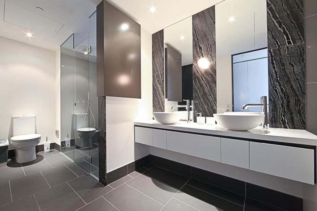 a bathroom with two sinks and two toilets at The ApARTments 403 Canberra City ACT in Canberra