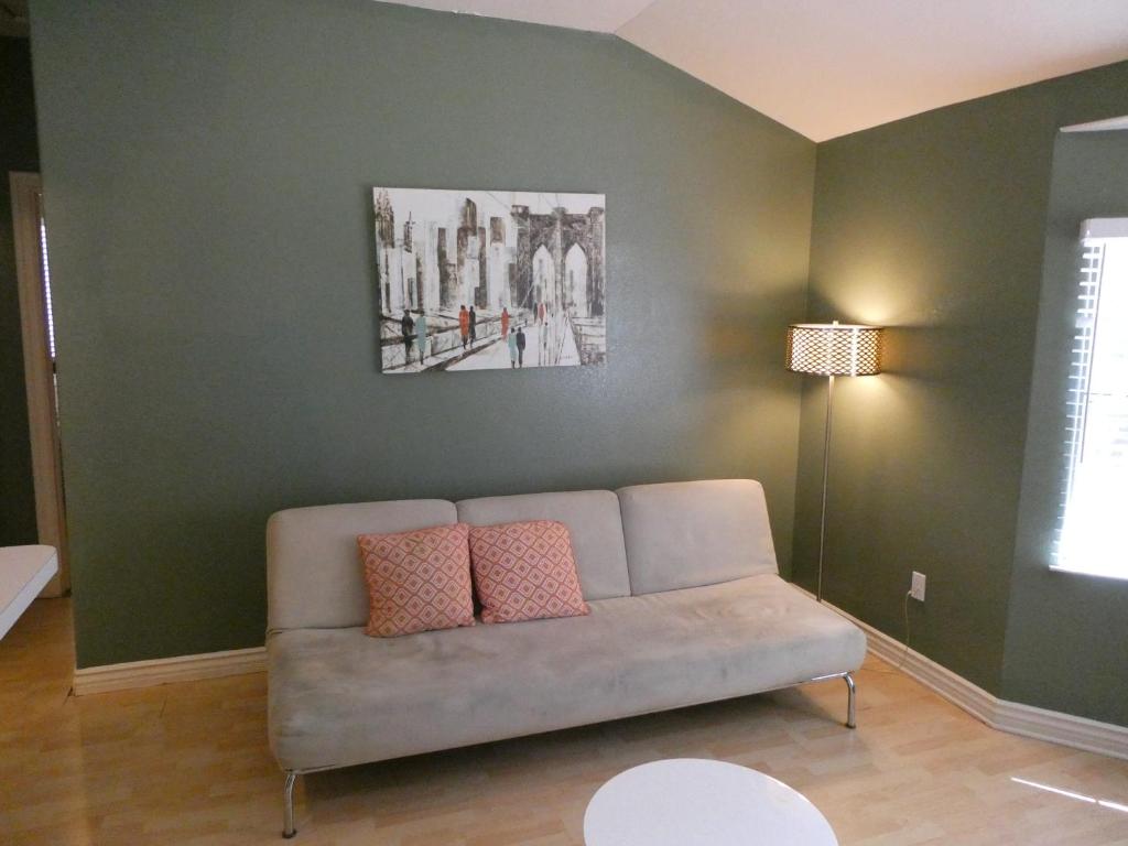 ein Wohnzimmer mit einem Sofa an einer grünen Wand in der Unterkunft Private 2 bedrooms 1 bath close to Universal and HW sleeps 5 in Los Angeles