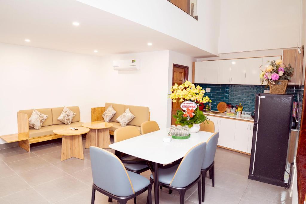 een keuken en een woonkamer met een tafel en stoelen bij Mai Hotel in Vung Tau