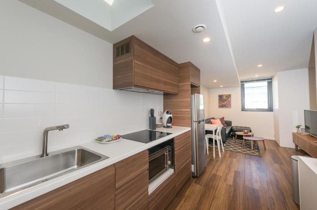 a kitchen with a sink and a refrigerator at Waygoose Street Residence Kingston ACT in Kingston 