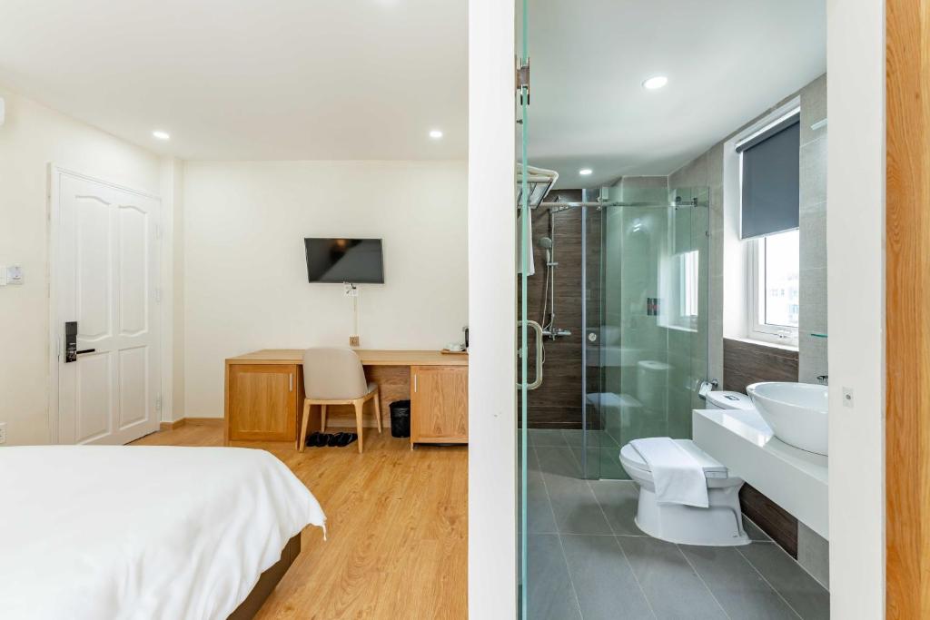 a bedroom with a bed and a bathroom with a shower at Edoya hotel Dong Khoi in Ho Chi Minh City