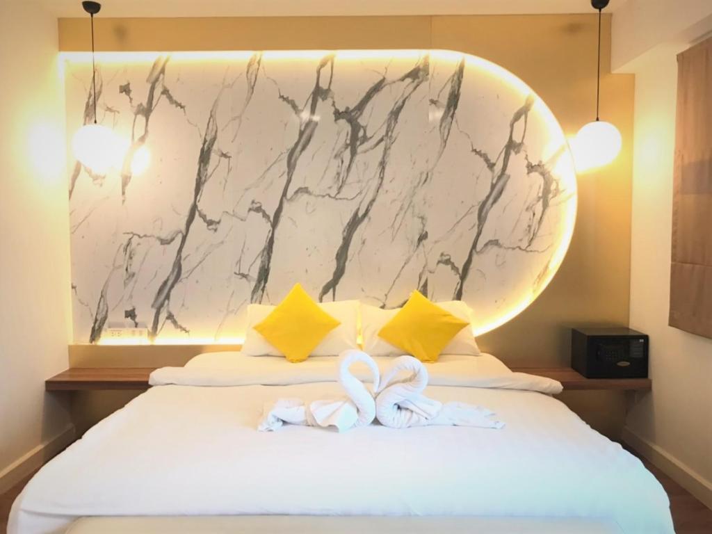 a hotel room with two towels on a bed at La La Moon Krabi Poshtel'n' Pool in Krabi