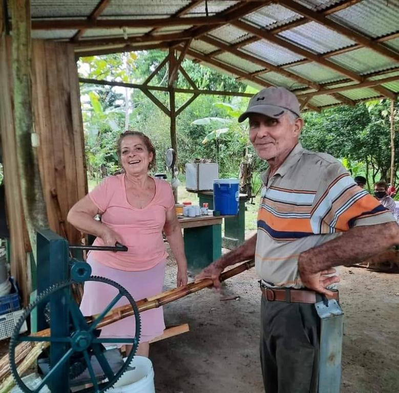 a man and a woman standing next to a machine at Finca Orgánica Guarumo in Heredia